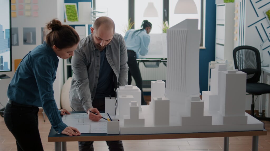 Constructor especializado en reformas de lujo en Madrid junto a interiorista revisando planos.